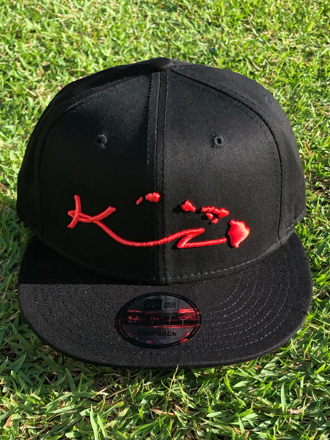 BLACK SNAP BACK HAT WITH RED LOGO AND ISLANDS